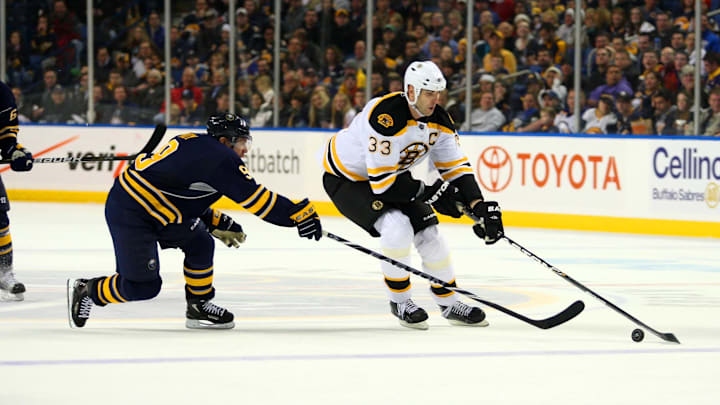 Dec 15, 2010; Buffalo, NY, USA;  Buffalo Sabres center Derek Roy (9) tries to reach for the puck against Boston Bruins defenseman Zdeno Chara (33) during the third period at HSBC Arena.  Sabres defeat the Bruins 3-2.  Mandatory Credit: Timothy T. Ludwig-Imagn Images