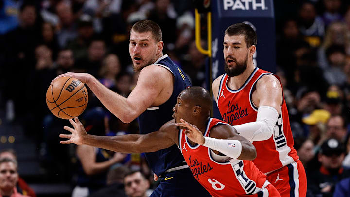 Dec 13, 2024; Denver, Colorado, USA; Los Angeles Clippers guard Kris Dunn (8) attempts to steal the ball away from Denver Nuggets center Nikola Jokic (15) as center Ivica Zubac (40) defends in the second quarter at Ball Arena. Dec 13, 2024; Denver, Colorado, USA; Los Angeles Clippers guard Kris Dunn (8) attempts to steal the ball away from Denver Nuggets center Nikola Jokic (15) as center Ivica Zubac (40) defends in the second quarter at Ball Arena.