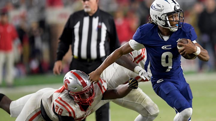 Clay-Chalkville's Jaylen Mbakwe (9) eludes Saraland's Jermaine Paramore, Jr., (88) and Camron Laffitte (10) during the AHSAA Class 6A football state championship game at Bryant Denny Stadium in Tuscaloosa, Ala., on Friday December 8, 2023.