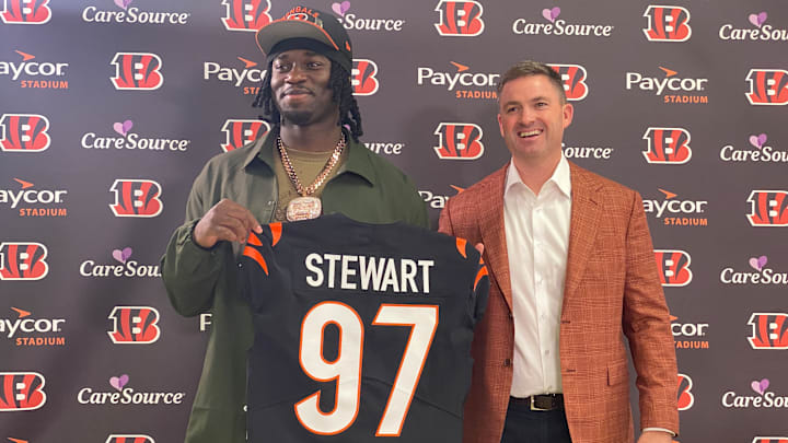 Bengals first-round pick Shemar Stewart holds up his jersey after landing in Cincinnati. 