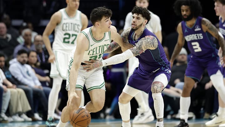 Boston Celtics guard Hugo González (28) keeps the ball away from Charlotte Hornets guard LaMelo Ball (1) during the second half