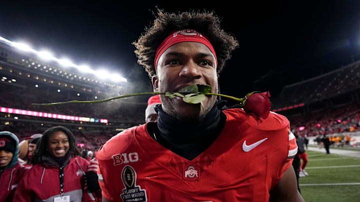 Ohio State safety Caleb Downs celebrates with a rose after the first-round College Football Playoff win because the Buckeyes will face the Oregon Ducks in the Rose Bowl.