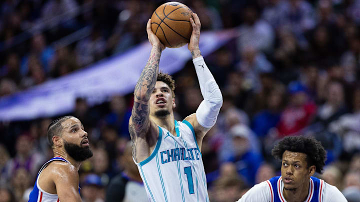 Nov 10, 2024; Philadelphia, Pennsylvania, USA; Charlotte Hornets guard LaMelo Ball (1) drives between Philadelphia 76ers forward Caleb Martin (L) and guard Jeff Dowtin Jr. (R) during the second quarter at Wells Fargo Center. Mandatory Credit: Bill Streicher-Imagn Images
