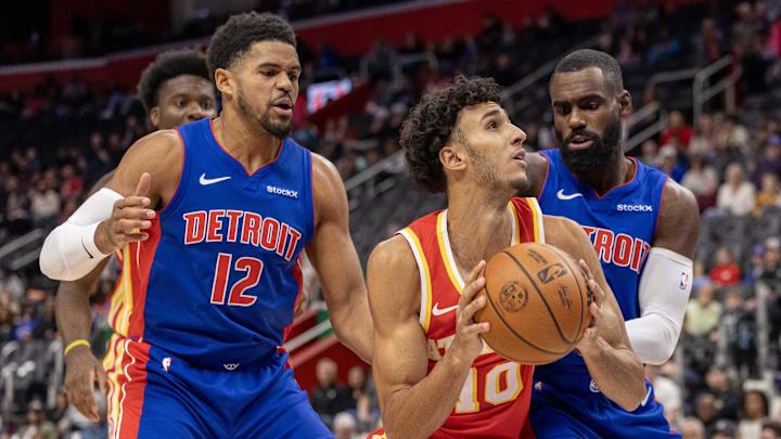 Nov 8, 2024; Detroit, Michigan, USA; Atlanta Hawks forward Zaccharie Risacher (10) battles for position with Detroit Pistons forward Tobias Harris (12) and forward Tim Hardaway Jr. (8) during the first half at Little Caesars Arena. Mandatory Credit: David Reginek-Imagn Images