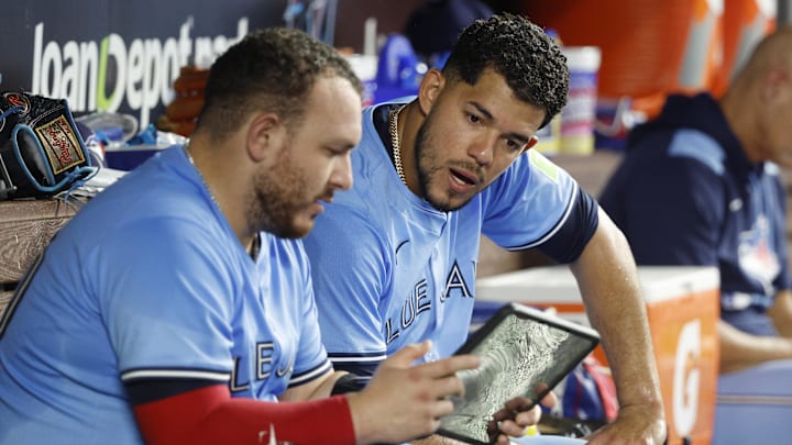 Jose Berrios of Toronto Blue Jays looks at tablet with teammate