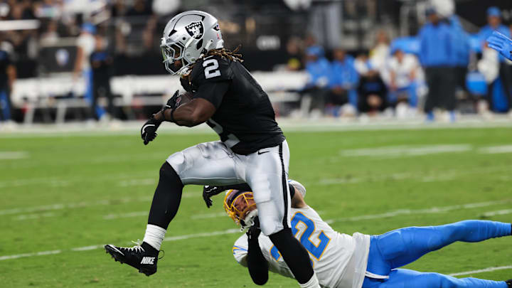 Sep 15, 2025; Paradise, Nevada, USA;  Las Vegas Raiders running back Ashton Jeanty (2) evades a tackle from Los Angeles Chargers safety Alohi Gilman (32) during the first quarter at Allegiant Stadium. 