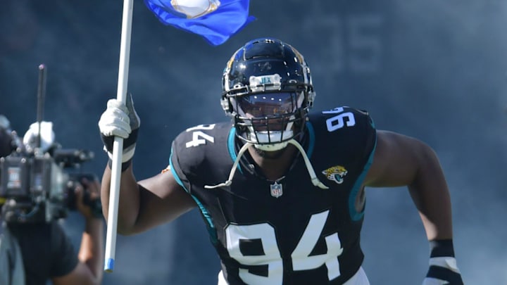 Jacksonville Jaguars defensive tackle Folorunso Fatukasi (94) runs onto the field carrying the U.S.