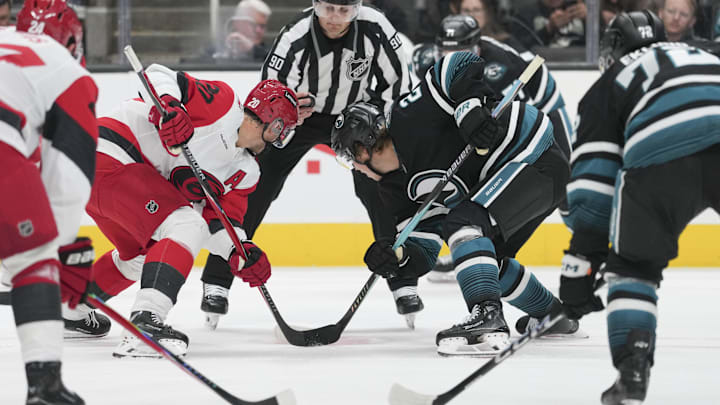 Oct 14, 2025; San Jose, California, USA;  Carolina Hurricanes center Sebastian Aho (20) and San Jose Sharks center Will Smith (2) face off during the third period at SAP Center at San Jose. Mandatory Credit: Stan Szeto-Imagn Images