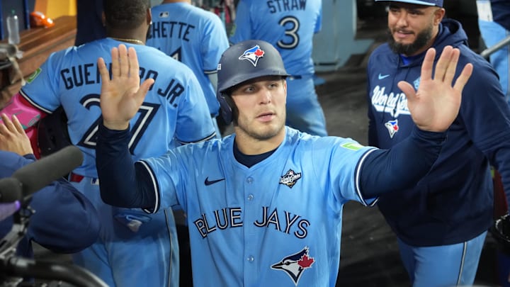 Toronto Blue Jays center fielder Daulton Varsho (5) celebrates in the dugout with his teammates