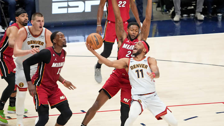 Jun 12, 2023; Denver, Colorado, USA; Denver Nuggets forward Bruce Brown (11) shoots the ball against Miami Heat forward Haywood Highsmith (back) and center Bam Adebayo (13) during the second quarter in game five of the 2023 NBA Finals at Ball Arena. Mandatory Credit: Kyle Terada-Imagn Images