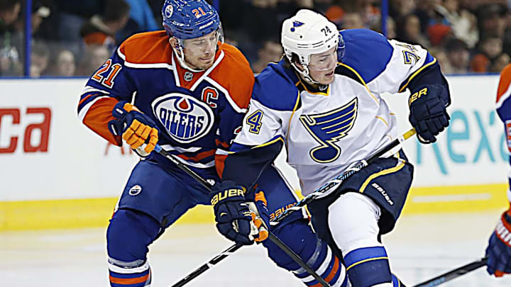 Jan 7, 2014; Edmonton, Alberta, CAN; St. Louis Blues forward TJ Oshie (74) and Edmonton Oilers defenseman Andrew Ference (21) battle for a loose puck during the second period  at Rexall Place. Mandatory Credit: Perry Nelson-Imagn Images