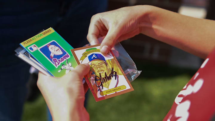 A young baseball player checks out his newly-autographed baseball card