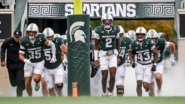 Michigan State's Aidan Chiles, center, and the Spartans take the field before the game against UCLA on Saturday, Oct. 11, 2025, at Spartan Stadium in East Lansing.