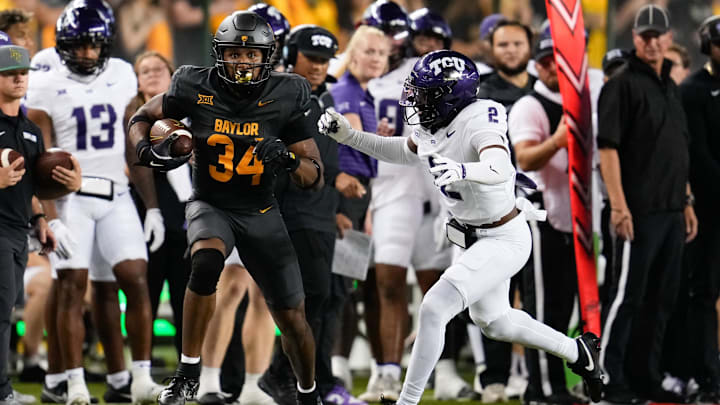 Nov 2, 2024; Waco, Texas, USA;  Baylor Bears wide receiver Josh Cameron (34) runs the ball after making a catch against TCU Horned Frogs safety Jamel Johnson (2) during the first half at McLane Stadium. Mandatory Credit: Chris Jones-Imagn Images