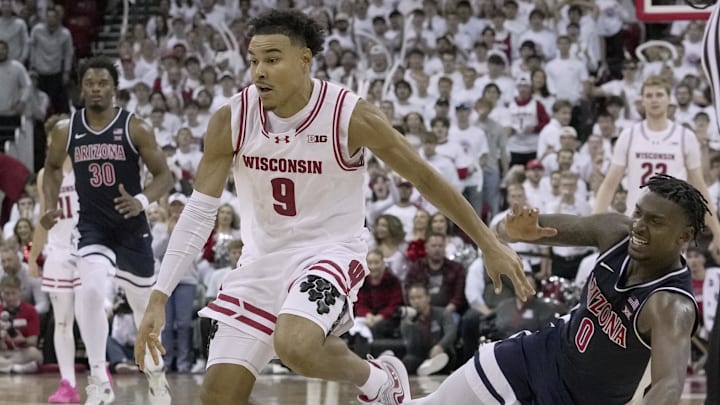 Nov 15, 2024; Madison, Wisconsin, USA;Arizona guard Jaden Bradley (0) fouls Wisconsin guard John Tonje (9) during the second half of their game Friday, November 15, 2024 at the Kohl Center in Madison, Wisconsin.  Mandatory Credit: Mark Hoffman/USA TODAY Network via Imagn Images 