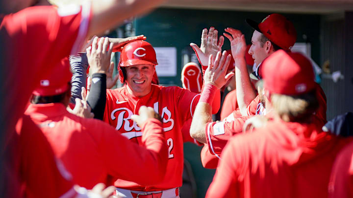 Cincinnati Reds right fielder JJ Bleday (22) is embraced by teammates in the dugout after hitting a homer in the third inning of a Cactus League game between the Cincinnati Reds and Chicago White Sox, Wednesday, Feb. 25, 2026, at