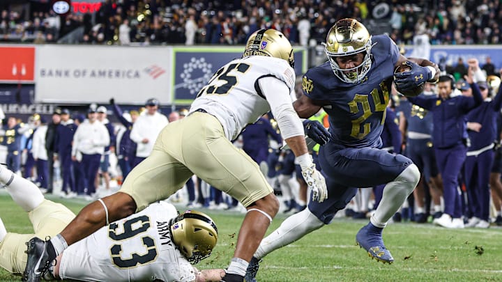Nov 23, 2024; New York, New York, USA; Notre Dame Fighting Irish running back Jadarian Price (24) scores a rushing touchdown as Army Black Knights defensive back Josiah Banks (25) and defensive lineman Cody Winokur (93) pursue during the second half at Yankee Stadium. Mandatory Credit: Vincent Carchietta-Imagn Images