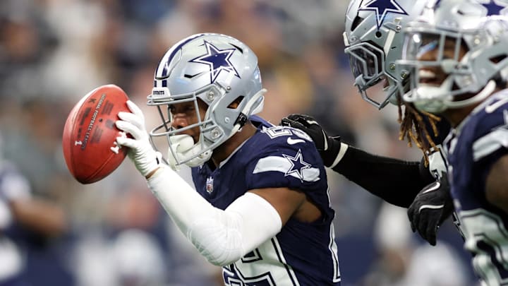 Dallas Cowboys cornerback C.J. Goodwin recovers a fumble against the Washington Commanders.