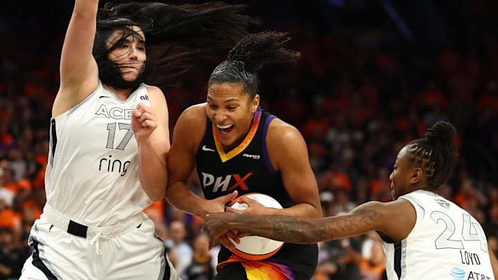 Oct 8, 2025; Phoenix, Arizona, USA;Phoenix Mercury forward Alyssa Thomas (25) dribbles past Las Vegas Aces center Megan Gustafson (17) and guard Jewell Loyd (24) in the second half during game three of the 2025 WNBA Finals at PHX Arena. Mandatory Credit: Mark J. Rebilas-Imagn Images
