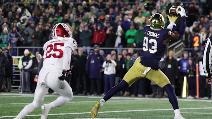 Dec 20, 2024; Notre Dame, Indiana, USA; Notre Dame Fighting Irish wide receiver Jayden Thomas (83) makes a touchdown catch against Indiana Hoosiers defensive back Amare Ferrell (25) during the first half at Notre Dame Stadium. 