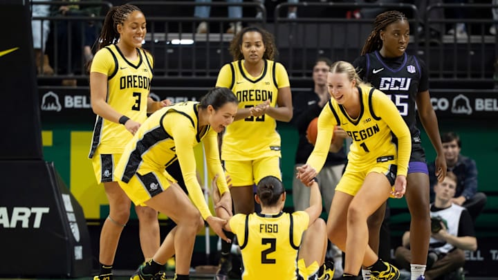 Oregon players help up teammate Oregon guard Katie Fiso after a foul as the Oregon Ducks host the Grand Canyon Antelopes Nov. 11, 2025, at Matthew Knight Arena in Eugene, Oregon.