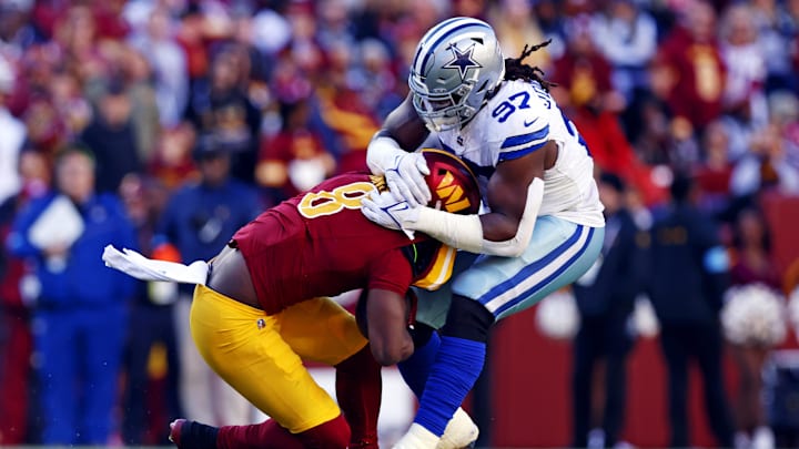 Nov 24, 2024; Landover, Maryland, USA; Washington Commanders running back Brian Robinson Jr. (8) is tackled by Dallas Cowboys defensive tackle Osa Odighizuwa (97) during the second quarter at Northwest Stadium. Mandatory Credit: Peter Casey-Imagn Images