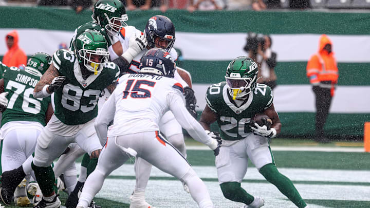 Sep 29, 2024; East Rutherford, New Jersey, USA; New York Jets running back Breece Hall (20) carries the ball as Denver Broncos linebacker Nik Bonitto (15) defends during the first half at MetLife Stadium.