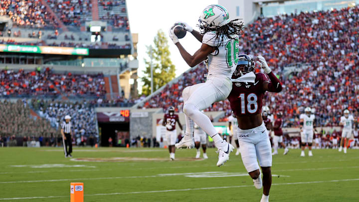 Sep 7, 2024; Blacksburg, Virginia, USA; Marshall Thundering Herd wide receiver Christian Fitzpatrick (16) catches a touchdown pass against Virginia Tech Hokies safety Mose Phillips III (18) during the second quarter at Lane Stadium. Mandatory Credit: Peter Casey-Imagn Images