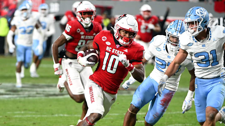 Nov 25, 2023; Raleigh, North Carolina, USA; North Carolina State Wolfpack receiver KC Concepcion (10) runs after a catch against North Carolina Tar Heels defensive back Will Hardy (31) during the first half at Carter-Finley Stadium. Mandatory Credit: Rob Kinnan-Imagn Images