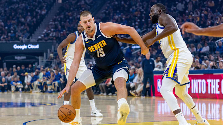 Oct 23, 2025; San Francisco, California, USA; Denver Nuggets center Nikola Jokic (15) controls the ball as. Golden State Warriors forward Draymond Green (23) defends during the first quarter at Chase Center. Mandatory Credit: Bob Kupbens-Imagn Images Oct 23, 2025; San Francisco, California, USA; Denver Nuggets center Nikola Jokic (15) controls the ball as. Golden State Warriors forward Draymond Green (23) defends during the first quarter at Chase Center. Mandatory Credit: Bob Kupbens-Imagn Images