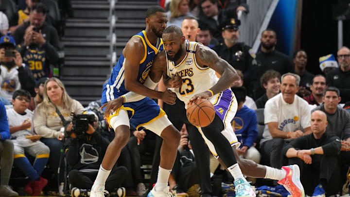 Dec 25, 2024; San Francisco, California, USA; Los Angeles Lakers forward LeBron James (23) dribbles against Golden State Warriors forward Andrew Wiggins (center left) during the third quarter at Chase Center. Mandatory Credit: Darren Yamashita-Imagn Images