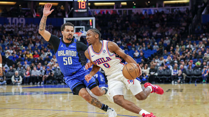 Jan 12, 2025; Orlando, Florida, USA; Philadelphia 76ers guard Tyrese Maxey (0) drives around Orlando Magic guard Cole Anthony (50) during the first quarter at Kia Center. Mandatory Credit: Mike Watters-Imagn Images