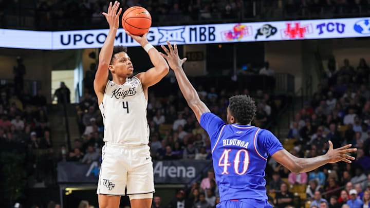 Jan 5, 2025; Orlando, Florida, USA; UCF Knights guard Keyshawn Hall (4) shoots over Kansas Jayhawks forward Flory Bidunga (40) during the first half at Addition Financial Arena. Mandatory Credit: Mike Watters-Imagn Images