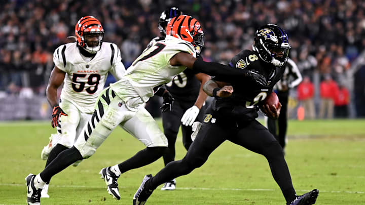 Nov 16, 2023; Baltimore, Maryland, USA; Cincinnati Bengals safety Jordan Battle (27) tackles Baltimore Ravens quarterback Lamar Jackson (8) during the fourth quarter at M&T Bank Stadium. Mandatory Credit: Tommy Gilligan-Imagn Images