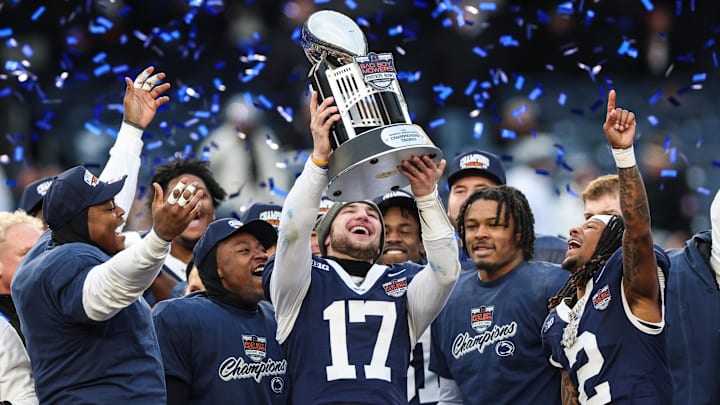 Penn State Nittany Lions quarterback Ethan Grunkemeyer (17) and teammates celebrate with the George M. Steinbrenner Trophy after defeating the Clemson Tigers in the 2025 Pinstripe Bowl at Yankee Stadium.