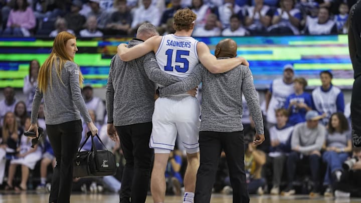 Feb 14, 2026; Provo, Utah, USA; BYU Cougars guard Richie Saunders (15) is helped off the court after an injury during the first half against the Colorado Buffaloes at the Marriott Center. Mandatory Credit: Aaron Baker-Imagn Images
