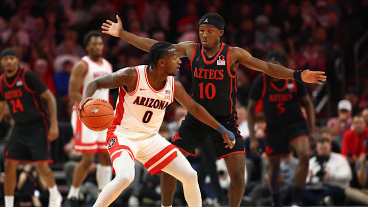 Dec 20, 2025; Phoenix, Arizona, USA; Arizona Wildcats guard Jaden Bradley (0) controls the ball against San Diego State Aztecs guard BJ Davis (10) during the Hall of Fame Series at Mortgage Matchup Center. 