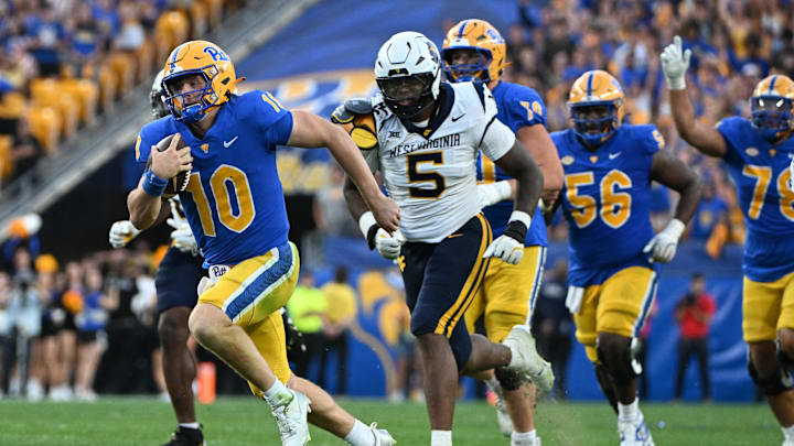 Sep 14, 2024; Pittsburgh, Pennsylvania, USA; Pittsburgh Panthers quarterback Eli Holstein (10) runs against West Virginia Mountaineers defensive lineman Sean Martin (5) during the fourth quarter at Acrisure Stadium. Mandatory Credit: Barry Reeger-Image Images