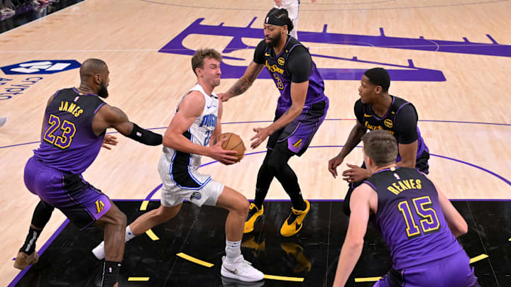 Nov 21, 2024; Los Angeles, California, USA; Orlando Magic forward Franz Wagner (22) drives past Los Angeles Lakers forward LeBron James (23), forward Anthony Davis (3) and guard Austin Reaves (15) at Crypto.com Arena. Mandatory Credit: Jayne Kamin-Oncea-Imagn Images