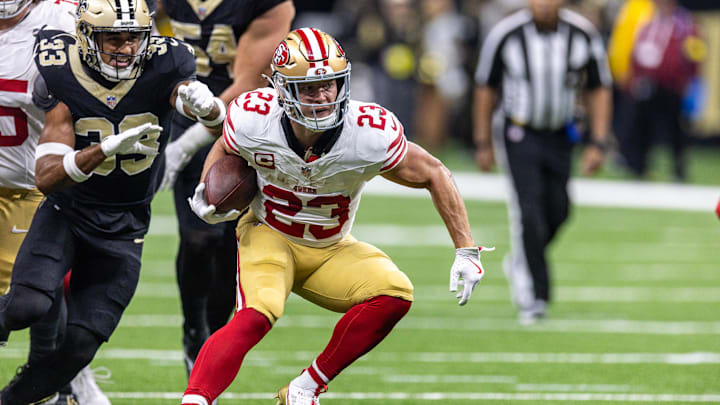 Sep 14, 2025; New Orleans, Louisiana, USA;  San Francisco 49ers running back Christian McCaffrey (23) runs against New Orleans Saints safety Jonas Sanker (33) during the first half at Caesars Superdome. Mandatory Credit: Stephen Lew-Imagn Images
