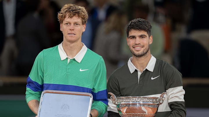 Jannik Sinner of Italy and Carlos Alcaraz of Spain pose together at the trophy presentation of the 2025 French Open.