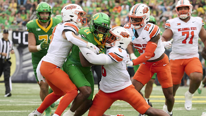 Sep 6, 2025; Eugene, Oregon, USA; Oregon Ducks wide receiver Jeremiah McClellan (11) is tackled during the first half by Oklahoma State Cowboys safety Parker Robertson (8) linebacker Brandon Rawls (6) at Autzen Stadium. Mandatory Credit: Troy Wayrynen-Imagn Images Sep 6, 2025; Eugene, Oregon, USA; Oregon Ducks wide receiver Jeremiah McClellan (11) is tackled during the first half by Oklahoma State Cowboys safety Parker Robertson (8) linebacker Brandon Rawls (6) at Autzen Stadium. Mandatory Credit: Troy Wayrynen-Imagn Images