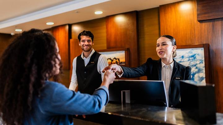 Receptionist giving key card to guest at hotel