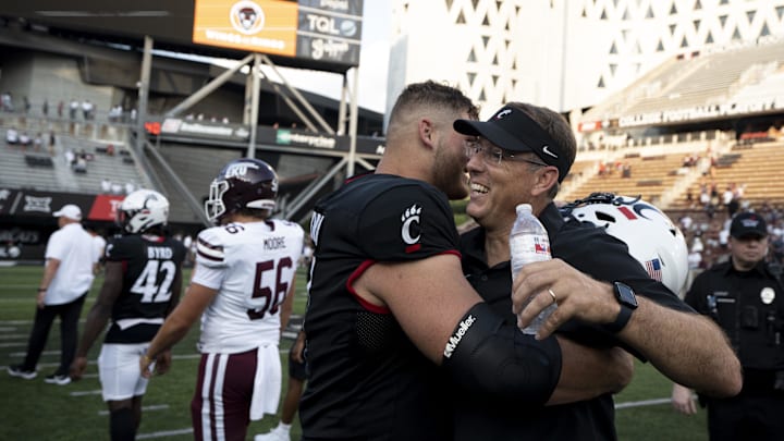 Sep 2, 2023; Cincinnati, Ohio, USA; Cincinnati Bearcats head coach Scott Satterfield embraces offensive lineman Luke Kandra (67) after a game against the Eastern Kentucky Colonels at Nippert Stadium. Mandatory Credit: Albert Cesare-Imagn Images