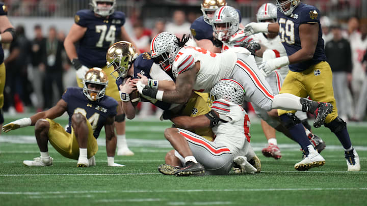 Jan 20, 2025; Atlanta, GA, USA; Notre Dame Fighting Irish quarterback Riley Leonard (13) is sacked by Ohio State Buckeyes safety Sonny Styles (6) and Ohio State Buckeyes defensive tackle Tyleik Williams (91) in the second half in the CFP National Championship college football game at Mercedes-Benz Stadium. 