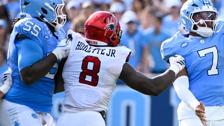 Sep 13, 2025; Chapel Hill, North Carolina, USA; North Carolina Tar Heels quarterback Gio Lopez (7) passes the ball as Richmond Spiders defensive lineman Donovan Hoilette (8) and defensive back Devin Geronomi (22) pressure in the second quarter at Kenan Stadium. Mandatory Credit: Bob Donnan-Imagn Images