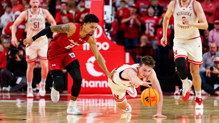 Dec 10, 2025; Lincoln, Nebraska, USA; Nebraska Cornhuskers forward Pryce Sandfort (21) dives for the ball against Wisconsin Badgers guard Nick Boyd (2) during the first half at Pinnacle Bank Arena.