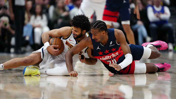 Mar 15, 2025; Denver, Colorado, USA; Washington Wizards forward Alex Sarr (20) and Denver Nuggets guard Jamal Murray (27) reach for the ball in the second half at Ball Arena. Mandatory Credit: Ron Chenoy-Imagn Images