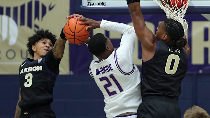 Akron Zips guard Sharron Young (3) and forward Amani Lyles (0) work to block James Madison Dukes forward Justin McBride (21) during the first half of an NCAA college basketball game at James A. Rhodes Arena, Nov. 3, 2025, in Akron, Ohio