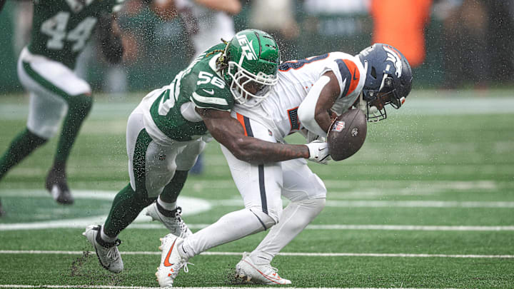 Sep 29, 2024; East Rutherford, New Jersey, USA; Denver Broncos running back Tyler Badie (28) fumbles after being hit by New York Jets linebacker Quincy Williams (56) during the first half at MetLife Stadium. 